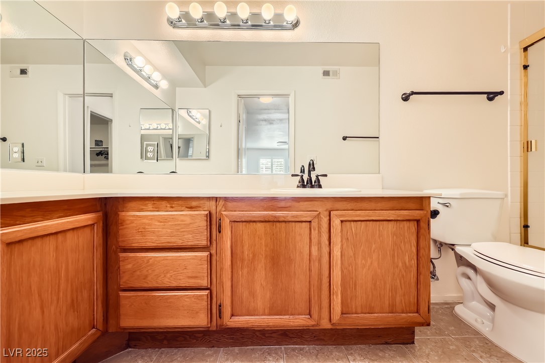 1575 West Warm Springs Road, Unit 1613 Henderson, NV 89014 - Photo 28 of 39 Bathroom with visible vents, toilet, vanity, and tile patterned floors