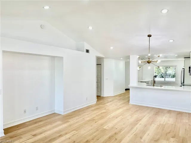 a view of a living room and kitchen with stainless steel appliances