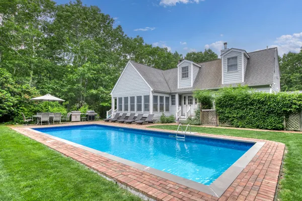 a view of a house with pool and chairs