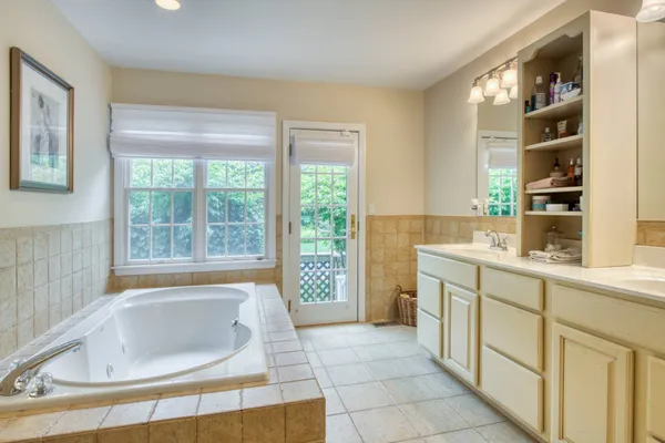 a bathroom with a tub sink and mirror
