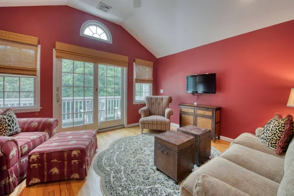 a living room with furniture a flat screen tv and a floor to ceiling window