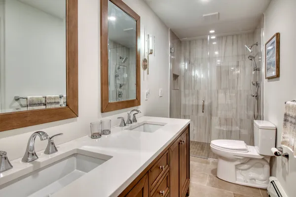 a bathroom with a sink a toilet and shower