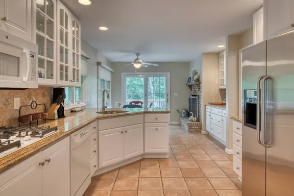 a large kitchen with a large window and stainless steel appliances