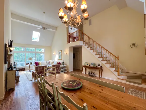 a view of a dining room with furniture a chandelier and wooden floor