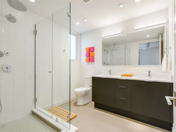 a spacious bathroom with a bathtub shower sink mirror and toilet