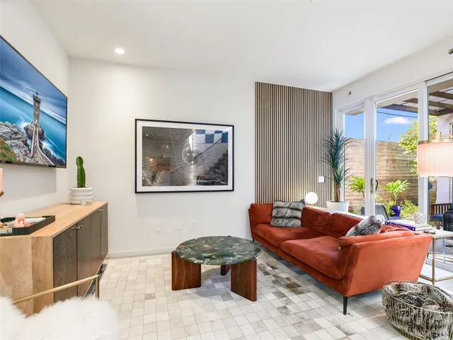 a living room with furniture a rug and a window