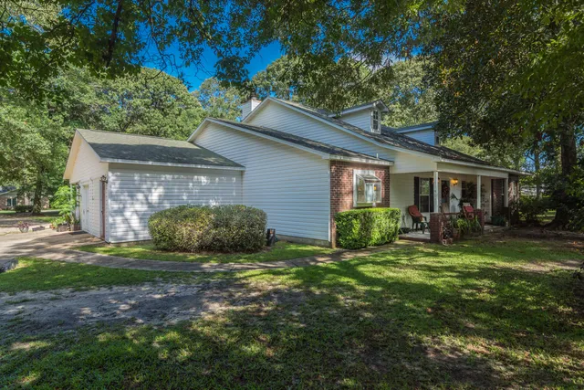 a view of a house with backyard and sitting area