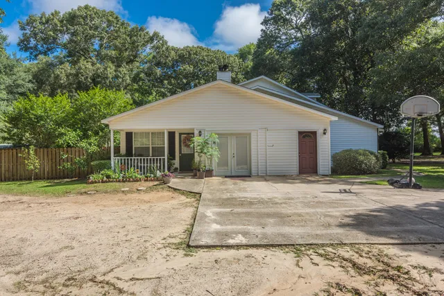 a white house with a large tree in front of it