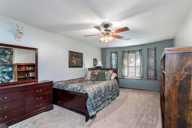 a spacious bedroom with a bed and a view of kitchen