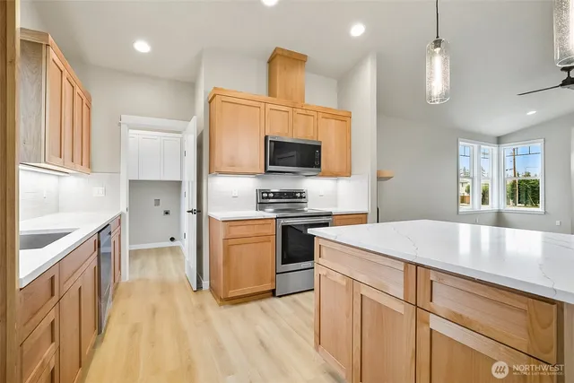an empty room with wooden floor cabinet and windows