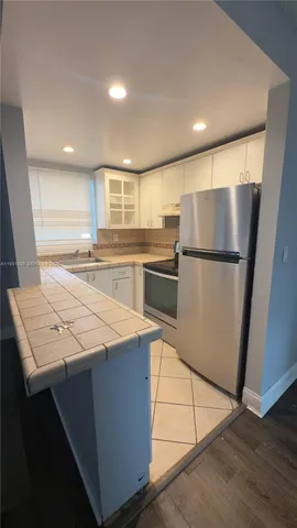 a kitchen with stainless steel appliances cabinets and wooden floor