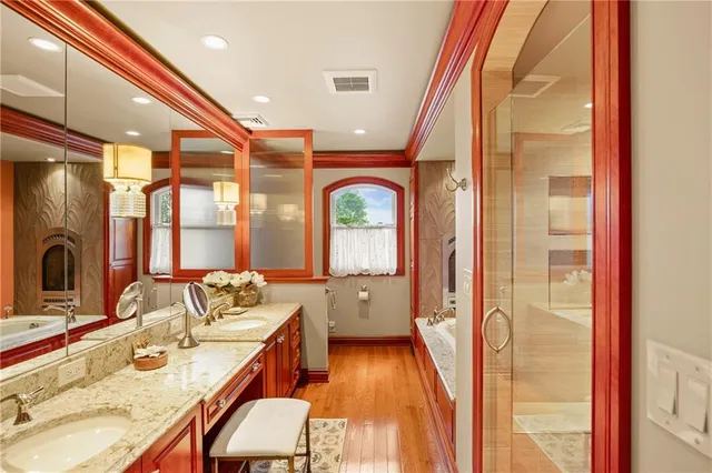 a bathroom with a granite countertop sink a mirror and a shower
