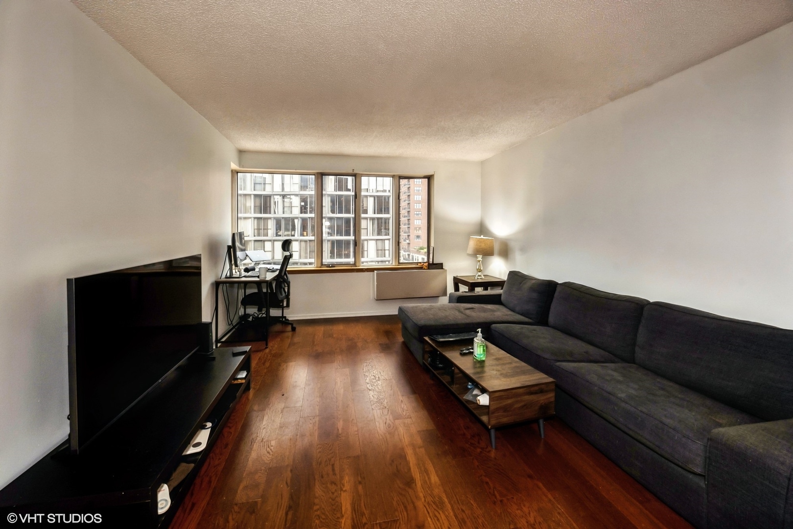 801 South Plymouth Court, Unit 809 Chicago, IL 60605 - Photo 3 of 10 a living room with furniture and a flat screen tv with wooden floor