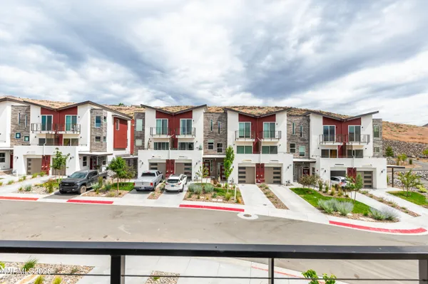 an aerial view of residential houses with cars parked