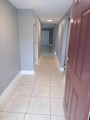 a view of hallway with a large mirror and a shower