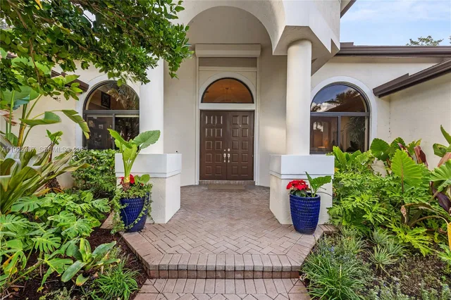 a front view of a house with yard and tress