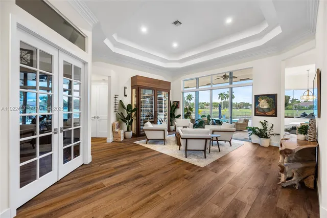 a kitchen with stainless steel appliances granite countertop a refrigerator a oven and white cabinets with wooden floor