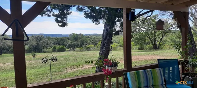 a view of a porch in front of a yard with wooden fence