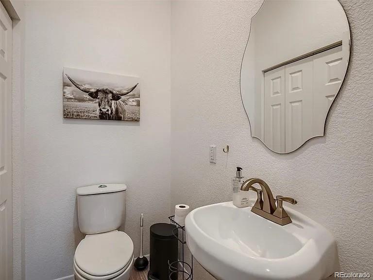 9910 Ammons Circle Westminster, CO 80021 - Photo 15 of 39 a bathroom with a toilet a sink and mirror