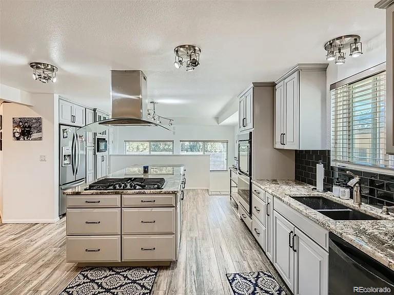 9910 Ammons Circle Westminster, CO 80021 - Photo 4 of 39 a kitchen with stainless steel appliances a stove a sink and a refrigerator