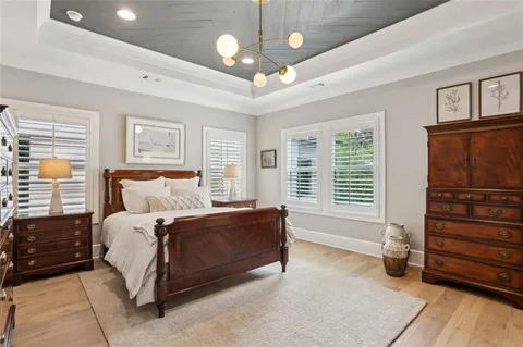 a spacious bathroom with a double vanity sink a two mirror a window and a bathtub