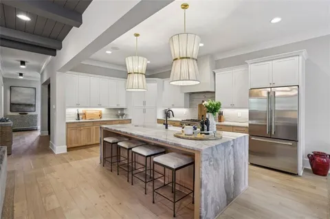 a kitchen with kitchen island stainless steel appliances a center island and a chandelier