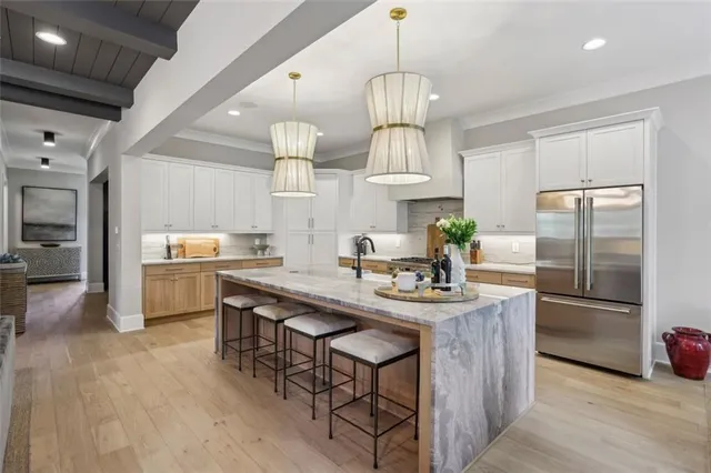 a kitchen with kitchen island stainless steel appliances a center island and a chandelier