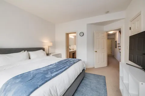 a spacious bedroom with a bed and a television