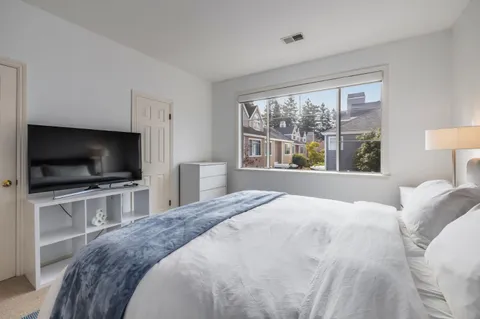 a bedroom with a bed and a flat screen tv