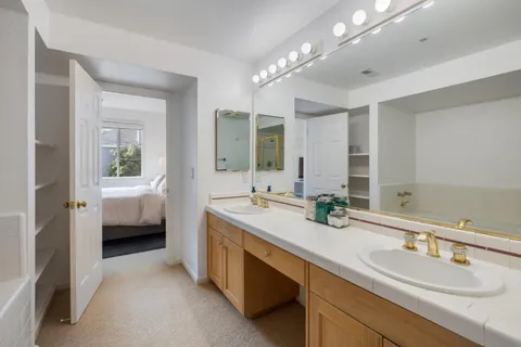 a spacious en suite bathroom with double sink and a large mirror