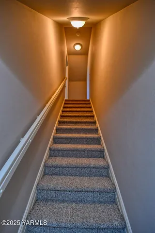 a bedroom with a bed and a lamp on dresser