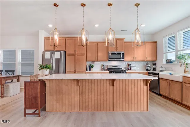 a kitchen with stainless steel appliances granite countertop a sink a counter space and wooden floor