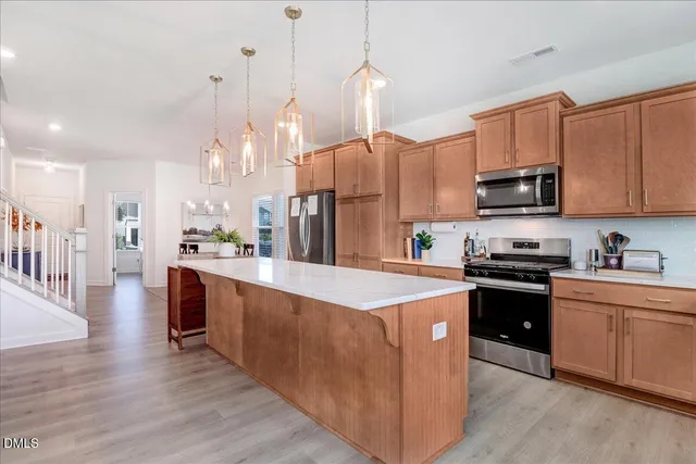a kitchen with stainless steel appliances a sink stove and cabinets