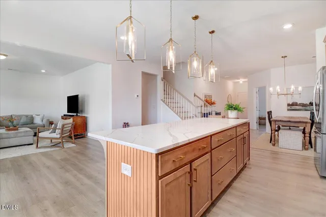 a kitchen with stainless steel appliances granite countertop a stove top oven a refrigerator a sink and a wooden floors