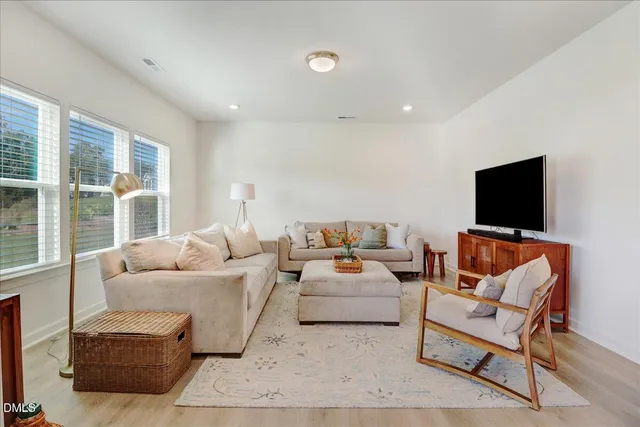 a large kitchen with stainless steel appliances kitchen island a large counter space a sink and living room view