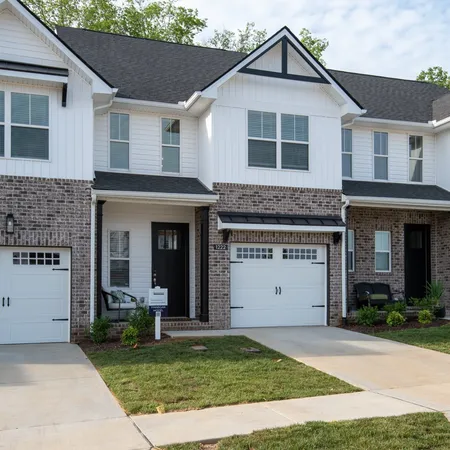 a view of a yard in front view of a house with garage