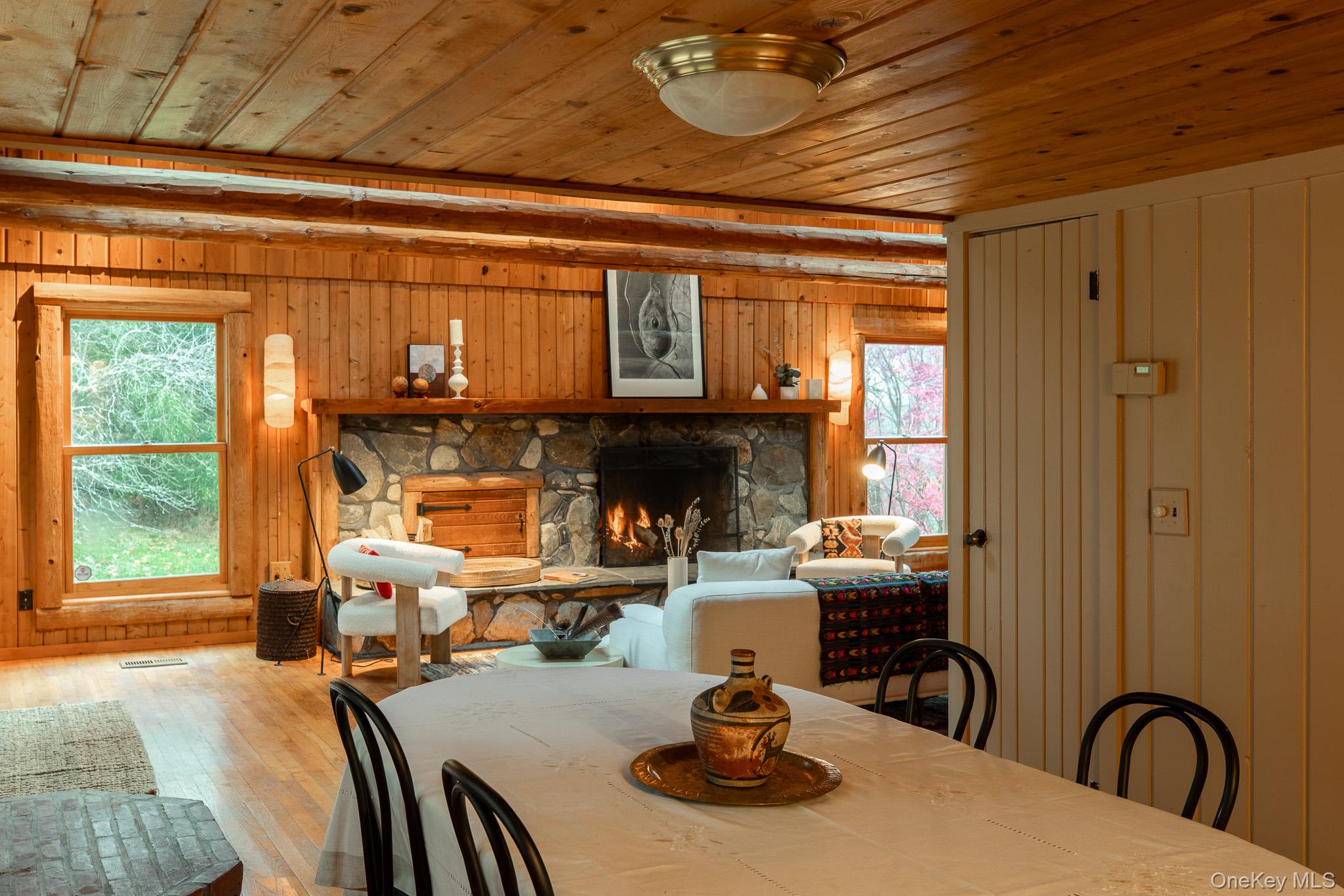 79 Torre Rock Road Red Hook, NY 12571 - Photo 14 of 33 Dining room featuring a stone fireplace, wood ceiling, hardwood / wood-style flooring, and wooden walls