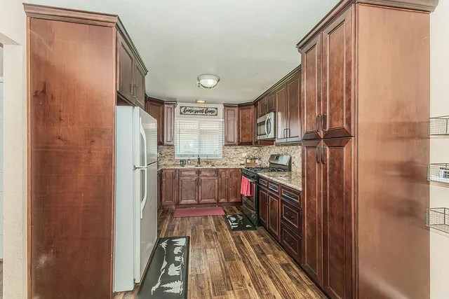 a kitchen with stainless steel appliances granite countertop a refrigerator and a stove top oven