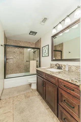 a bathroom with a granite countertop sink mirror and bathtub