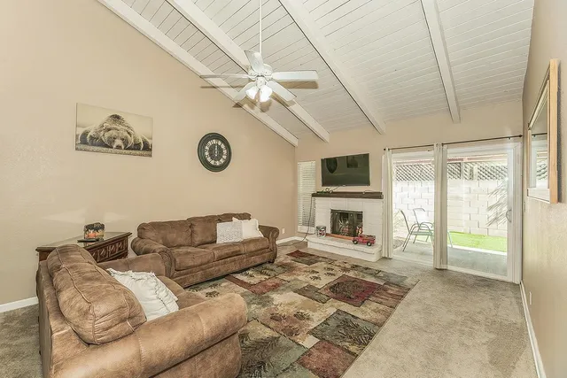 a living room with furniture a fireplace and a flat screen tv