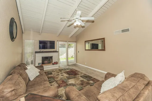 a living room with furniture a fireplace and a flat screen tv