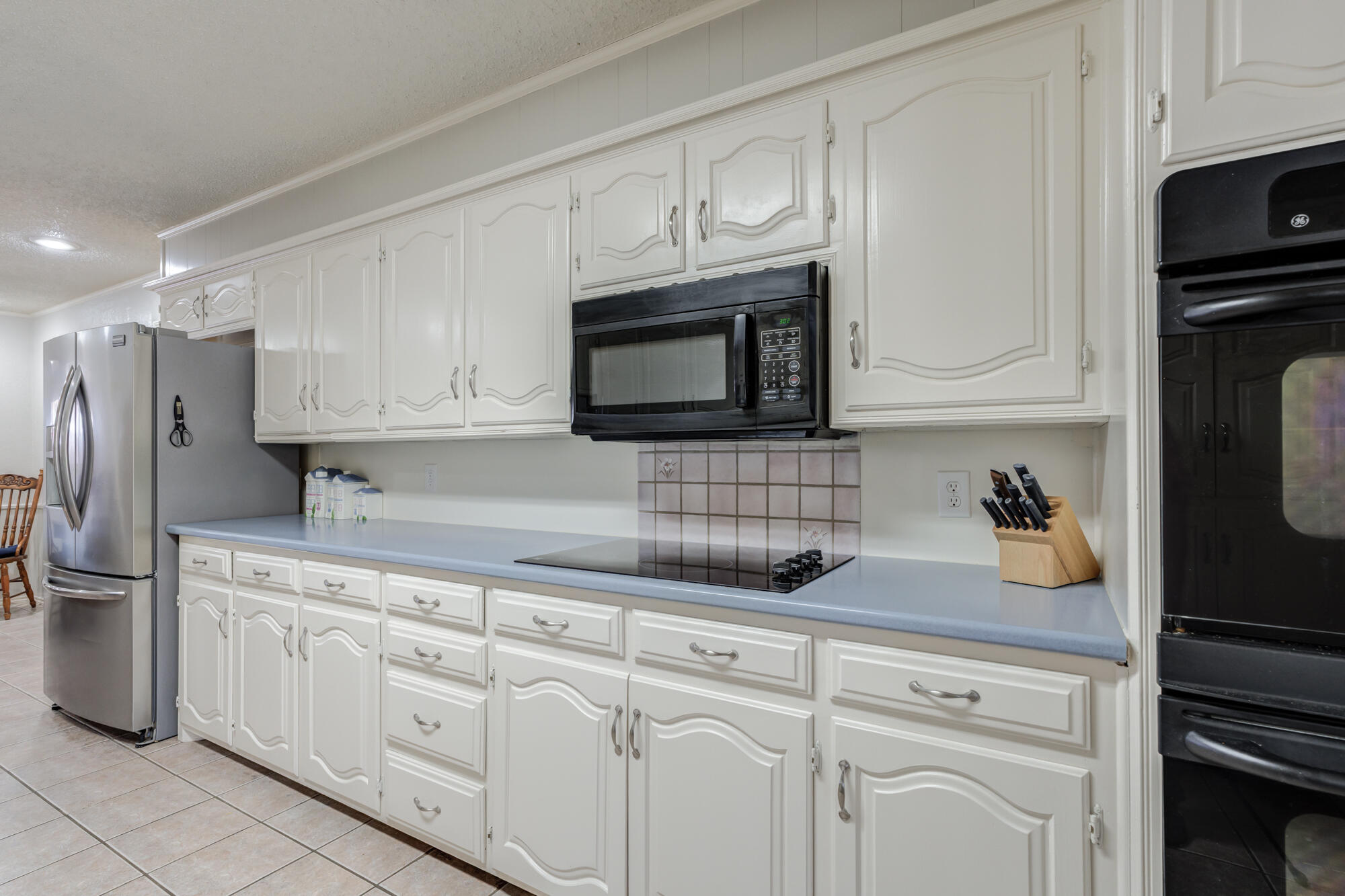 4809 78th Street Lubbock, TX 79424 - Photo 13 of 48 a kitchen with white cabinets and stainless steel appliances