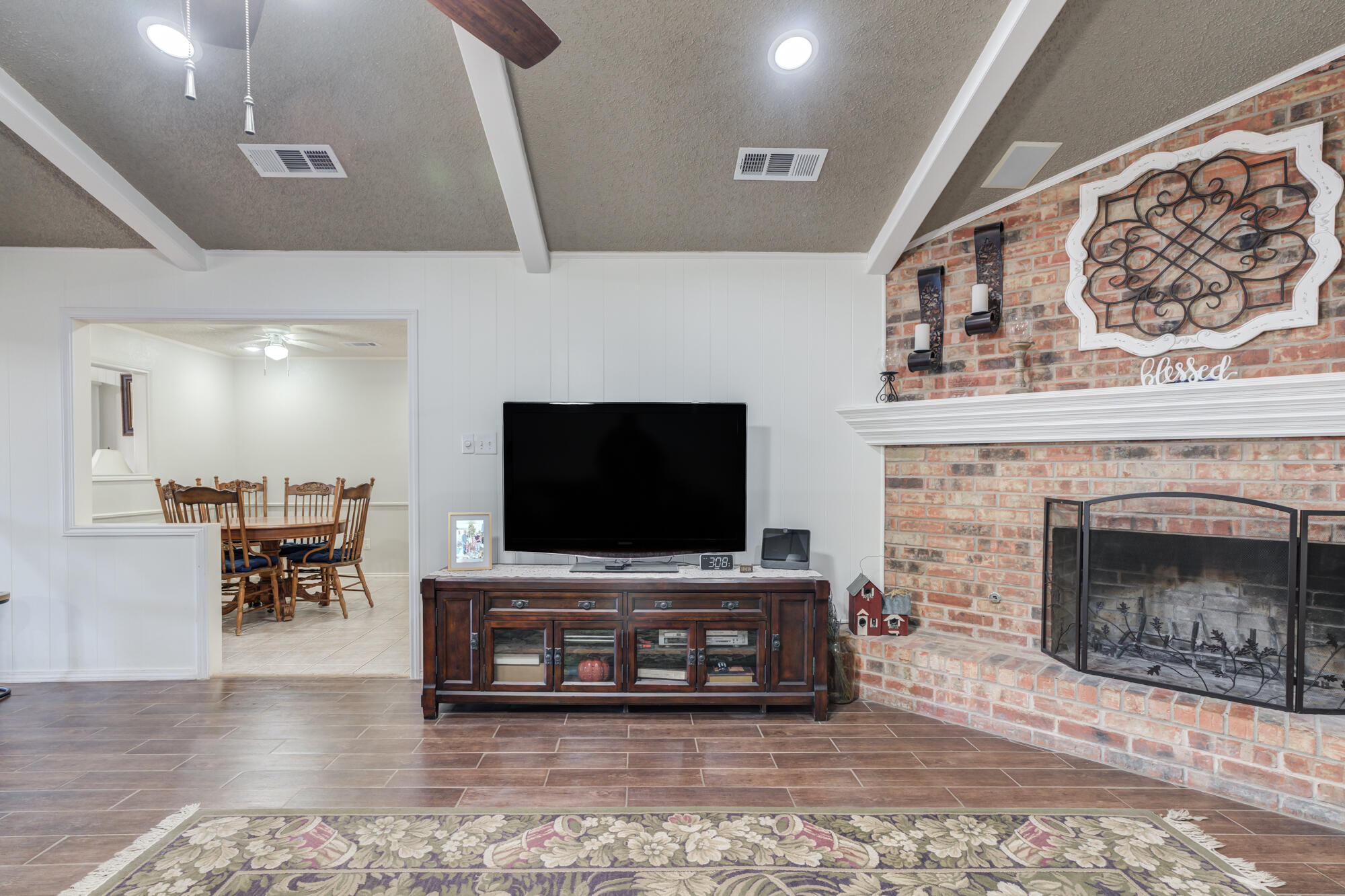 4809 78th Street Lubbock, TX 79424 - Photo 20 of 48 a living room with furniture a fireplace and a flat screen tv