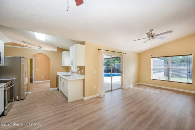 a living room with furniture a table and a large window