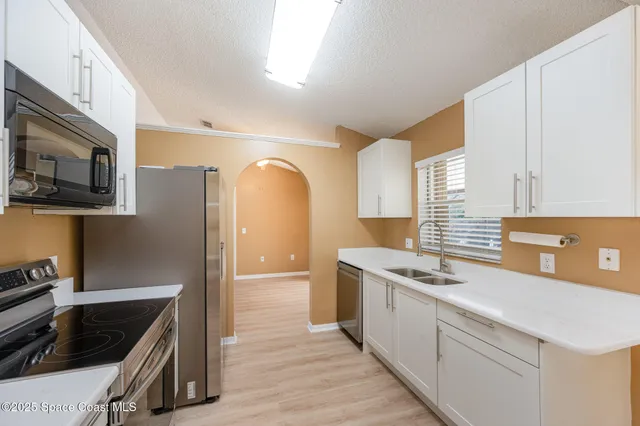 a kitchen with stainless steel appliances a stove a sink and a refrigerator
