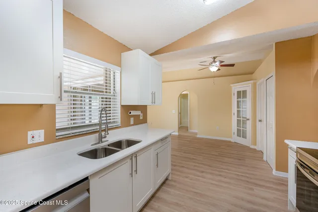 a kitchen that has a sink and a stove top oven