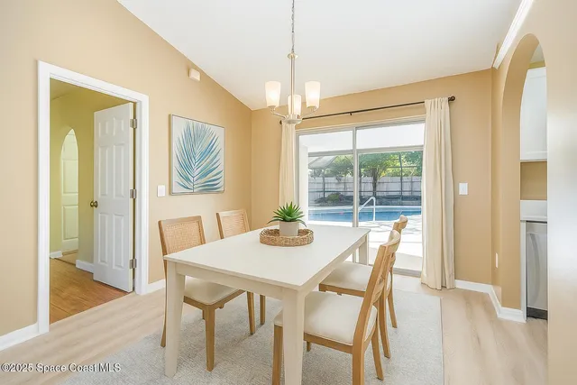 a view of an empty room with glass door and wooden floor