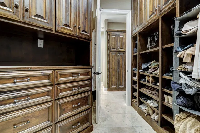 a view of walk in closet with clothes and shoes
