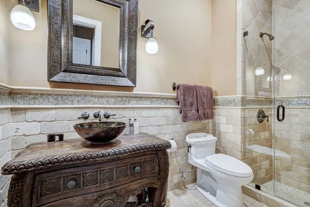 a bathroom with a granite countertop toilet a sink and a mirror
