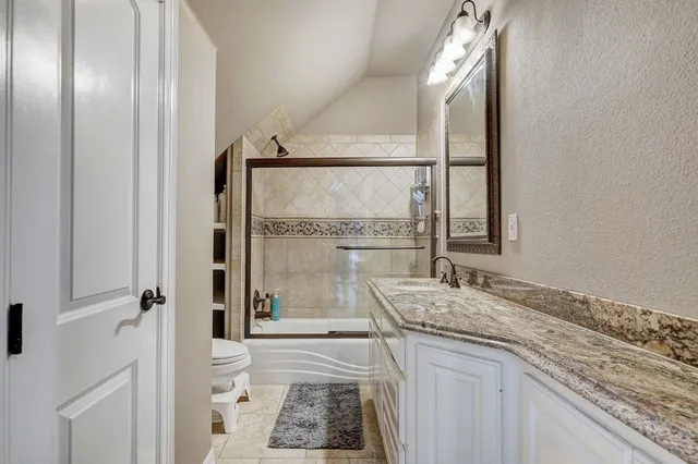 a bathroom with a granite countertop sink a mirror and a shower